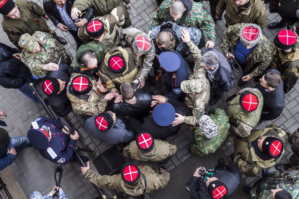 Люди в казачьей форме пытаются поставить на колени охранника, сопровождавшего команду Алексея Навального в Ростове-на-Дону. Фото: Евгений Фельдман / navalny.feldman.photo